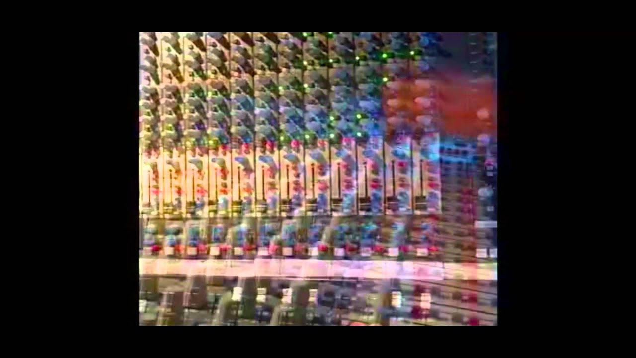 Video still: the faders and knobs of a large mixing desk, double-exposed