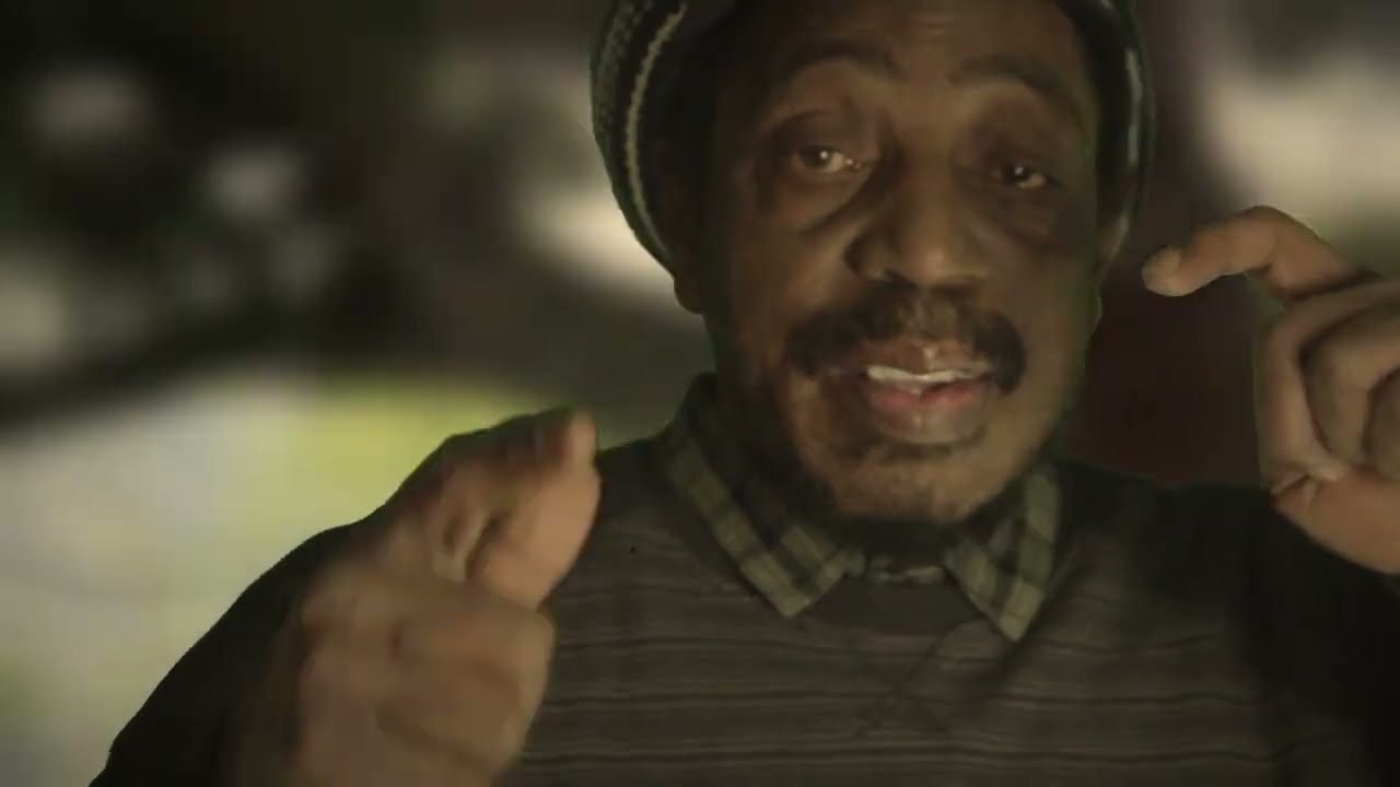 Video still: a close-up of a singer in a knitted hat and checked shirt